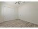 Bedroom with a ceiling fan, wood-look flooring, and a closet with sliding doors for maximized storage at 13430 S Garnet Rd, Buckeye, AZ 85326