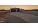 Stunning exterior showcasing desert landscaping, long driveway, and a vibrant sunset at 13430 S Garnet Rd, Buckeye, AZ 85326