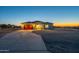 New home featuring a long driveway, desert landscaping, and exterior lights at 13430 S Garnet Rd, Buckeye, AZ 85326