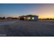 New home featuring a long driveway, desert landscaping, and exterior lights at 13430 S Garnet Rd, Buckeye, AZ 85326