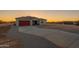 Beautiful home featuring a long concrete driveway and desert landscaping at sunset at 13430 S Garnet Rd, Buckeye, AZ 85326