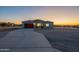 New home featuring a long driveway, desert landscaping, and a red garage door at 13430 S Garnet Rd, Buckeye, AZ 85326