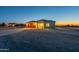 Newly constructed home with a long driveway, desert landscaping, and exterior lights at 13430 S Garnet Rd, Buckeye, AZ 85326