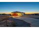 New home featuring a long driveway, desert landscaping, and exterior lights at 13430 S Garnet Rd, Buckeye, AZ 85326
