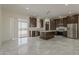 Bright open concept kitchen with large island, stainless appliances, and tile floors at 13430 S Garnet Rd, Buckeye, AZ 85326