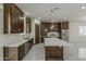 Spacious kitchen features dark wood cabinetry, stainless steel appliances, and a central island at 13430 S Garnet Rd, Buckeye, AZ 85326