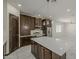 Bright kitchen with stainless appliances, island with seating, and dark cabinets at 13430 S Garnet Rd, Buckeye, AZ 85326