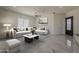 Staged living room with stylish decor, a ceiling fan, and grey tile flooring at 13430 S Garnet Rd, Buckeye, AZ 85326