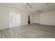 Spacious living room with wood-look floors, ceiling fans, recessed lights, and sliding glass door at 13430 S Garnet Rd, Buckeye, AZ 85326