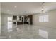 View of the living space flowing into the open kitchen with dark cabinets and stainless steel appliances at 13430 S Garnet Rd, Buckeye, AZ 85326