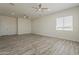 Bright living room featuring wood-look flooring, neutral walls, and a window with blind at 13430 S Garnet Rd, Buckeye, AZ 85326