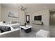 Living room with grey tile flooring, ceiling fan, and ample natural light at 13430 S Garnet Rd, Buckeye, AZ 85326