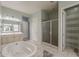 Lovely bathroom featuring a soaking tub, glass shower and and vanities with soft blue walls at 15655 W Berkeley Rd, Goodyear, AZ 85395