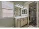 Well-lit bathroom featuring a window, modern vanity, and a peek into the walk-in closet at 15655 W Berkeley Rd, Goodyear, AZ 85395