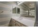 Bright bathroom with a large mirror, white countertops, and modern fixtures in a striped accent wall at 15655 W Berkeley Rd, Goodyear, AZ 85395