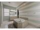 Spacious bathroom featuring a soaking tub, double vanity, and blue-and-white striped accent wall at 15655 W Berkeley Rd, Goodyear, AZ 85395