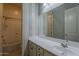 Well-lit bathroom featuring a large vanity with a mirror and a shower/tub with tile surround at 15655 W Berkeley Rd, Goodyear, AZ 85395