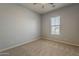 Bright bedroom with neutral carpet, a ceiling fan, and a window providing natural light at 15655 W Berkeley Rd, Goodyear, AZ 85395