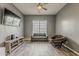 Home bonus room includes modern light fixture, entertainment center, grey sofa, and papasan chair at 15655 W Berkeley Rd, Goodyear, AZ 85395