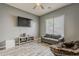 Cozy bonus room with gray walls, wood-look flooring, couch and papasan, modern light, and media center at 15655 W Berkeley Rd, Goodyear, AZ 85395