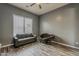 A light grey bonus room showcases wood-look floors, couch, a papasan, and a window at 15655 W Berkeley Rd, Goodyear, AZ 85395