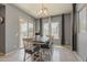 Open dining area featuring a stylish chandelier and access to outdoor pool through sliding glass door at 15655 W Berkeley Rd, Goodyear, AZ 85395