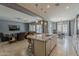 Bright kitchen featuring an island with granite countertops, an open floor plan, and seamless flow into the living area at 15655 W Berkeley Rd, Goodyear, AZ 85395