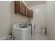 Functional laundry room featuring a washer, dryer, cabinetry and tile flooring at 15655 W Berkeley Rd, Goodyear, AZ 85395