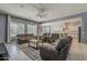 Open-concept living area showcasing a large sectional sofa, ceiling fan, and views into the kitchen and dining areas at 15655 W Berkeley Rd, Goodyear, AZ 85395