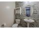 This powder room includes a pedestal sink, a toilet, and modern, decorative wallpaper at 15655 W Berkeley Rd, Goodyear, AZ 85395