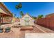 Backyard features a cute shed with a wood deck and green door, under a clear blue sky dotted with palm trees at 15825 N 45Th St, Phoenix, AZ 85032