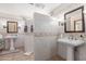 Bright bathroom featuring dual sinks, vanity lighting, tiled walls, and an open concept shower at 15825 N 45Th St, Phoenix, AZ 85032