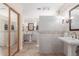 Spacious bathroom with dual pedestal sinks, tiled walls, and elegant mirrors at 15825 N 45Th St, Phoenix, AZ 85032