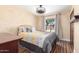 Cozy bedroom with wooden floors, a view to the backyard, and decorative bedding at 15825 N 45Th St, Phoenix, AZ 85032