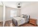 A cozy bedroom with wood floors, a window with blinds, a ceiling fan, and decorative bedding at 15825 N 45Th St, Phoenix, AZ 85032