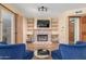 Cozy living room featuring a brick fireplace, built-in shelves, wood flooring, and comfortable seating at 15825 N 45Th St, Phoenix, AZ 85032