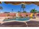 Backyard pool view showcasing two water slides, a rock waterfall, and mature desert palm trees at 15825 N 45Th St, Phoenix, AZ 85032