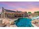 Backyard pool with a slide and stone features is surrounded by a fence and has a covered patio area for relaxing at 15825 N 45Th St, Phoenix, AZ 85032