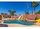 Backyard pool with rock waterfall feature, slide, spa, mature palm trees, and guest house at 15825 N 45Th St, Phoenix, AZ 85032