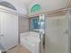 Bathroom featuring a soaking tub, separate shower, tiled floors, and a bright window for natural light at 16661 W Central St, Surprise, AZ 85388