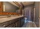 Bathroom with double sinks, large mirror, and shower with curtain at 18633 W Mcneil St, Goodyear, AZ 85338