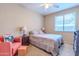 Cozy bedroom with natural light, comfortable bed with patterned linens, and sitting area with a chair and ottoman at 18633 W Mcneil St, Goodyear, AZ 85338