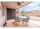 Spacious covered patio with tile flooring, a ceiling fan, outdoor dining set, and desert landscaping views at 18633 W Mcneil St, Goodyear, AZ 85338
