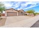 Stunning view of the home featuring a large three-car garage and beautiful desert landscaping at 18633 W Mcneil St, Goodyear, AZ 85338