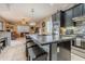 This kitchen features a large island with seating for three and stainless steel appliances at 18633 W Mcneil St, Goodyear, AZ 85338