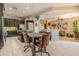 This open-concept kitchen features black cabinets, a marble island, tile floors, and eat in space at 18633 W Mcneil St, Goodyear, AZ 85338