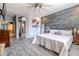 Spacious main bedroom with stone accent wall, ceiling fan and light wood look floors at 18633 W Mcneil St, Goodyear, AZ 85338