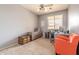Bright office features neutral walls, carpet, a ceiling fan, large window, and a comfortable orange chair at 18633 W Mcneil St, Goodyear, AZ 85338