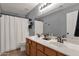Clean bathroom with double sinks, bright lighting, and a shower with a white curtain at 20239 N 39Th Dr, Glendale, AZ 85308
