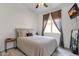 Cozy bedroom with a neutral color palette, tile floors, ceiling fan, and a large window at 20239 N 39Th Dr, Glendale, AZ 85308